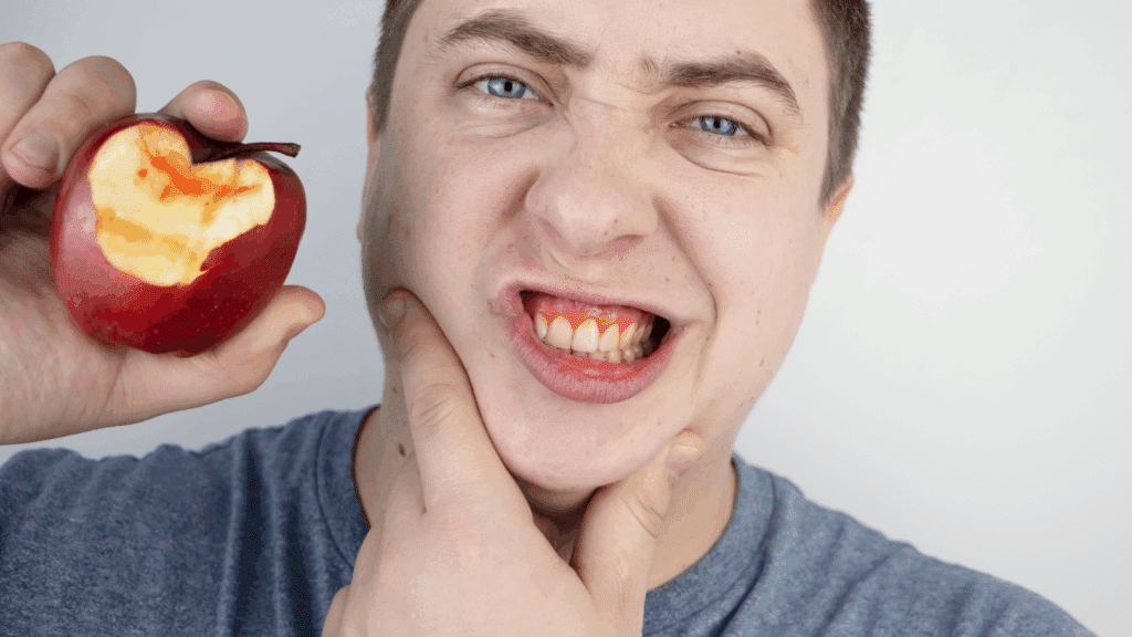Man biting into an apple - Understanding-Periodontitis-Causes-and-Treatments-blog-post